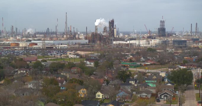 Establishing reveal shot of homes near heavy industry and chemical plants in the Baytown, Texas area
