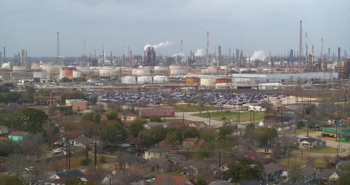 Establishing reveal shot of homes near heavy industry and chemical plants in the Baytown, Texas area