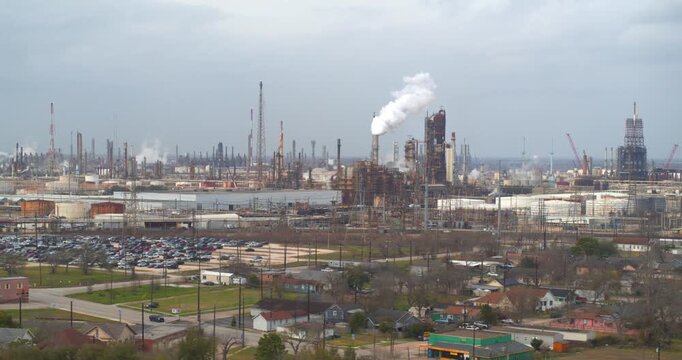 Establishing reveal shot of homes near heavy industry and chemical plants in the Baytown, Texas area