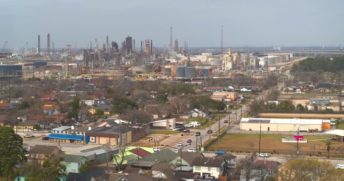 Establishing reveal shot of homes near heavy industry and chemical plants in the Baytown, Texas area