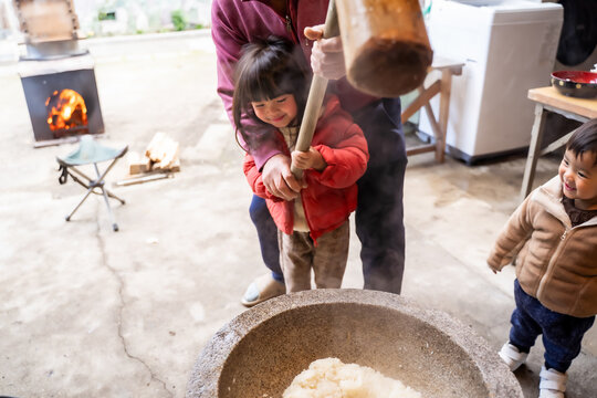 実家でお餅つきをする家族