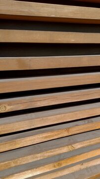 Vertical video. Wooden background consisting of long parallel wooden blocks. Wooden wall texture, architectural style. Clean, rhythmic, and natural aesthetic.