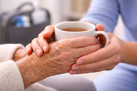 Caregiver Offering Warm Tea to Elderly Woman Comfort Care and Senior Support Concept