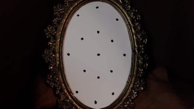 Atmospheric upward camera panorama moves from a small antique brass shoe-shaped jewelry hold to an ornate oval gold frame mockup with black tracking dots on rich brown fabric