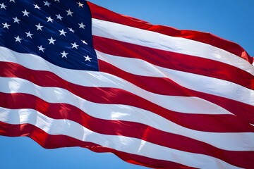 Obraz premium The american flag waving majestically in the clear blue sky on a sunny day