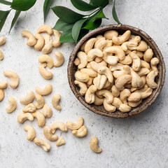 Dry cashew nuts in bowl, grey background, healthy vegan snack
