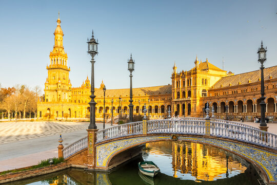 Travel, tourism: Ornate bridge spans a canal with a boat in Plaza de Espa&ntilde;a, Seville, Spain. Architecture and culture.