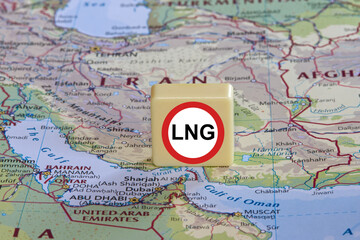 Naklejka premium Prohibition of transit transportation of LNG sign on a plastic box near the Strait of Hormuz on a map, close-up.