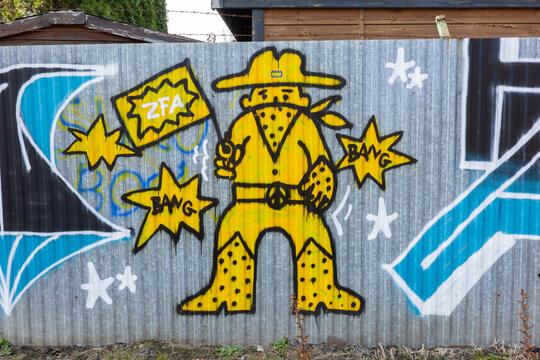 WARSAW, MAZOWIECKIE, POLAND - 2026 03 18: Graffiti street art of a yellow cowboy on a corrugated metal fence in Warsaw, Poland.