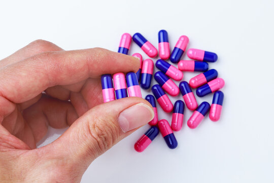 Close-up of human hand holding omeprazole gastro-resistant capsules (proton pump inhibitor) for gastrointestinal treatment