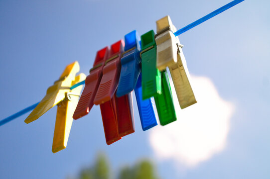 Colorful clothes pegs on a clothesline against a blue sky