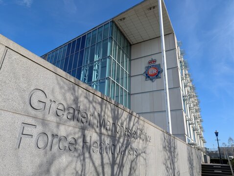 Manchester England UK 18 03 2026 Grater Manchester Police Force Headquarters. A view of the exterior of the building showing the front facade and force logo against a blue sky with wispy clouds.