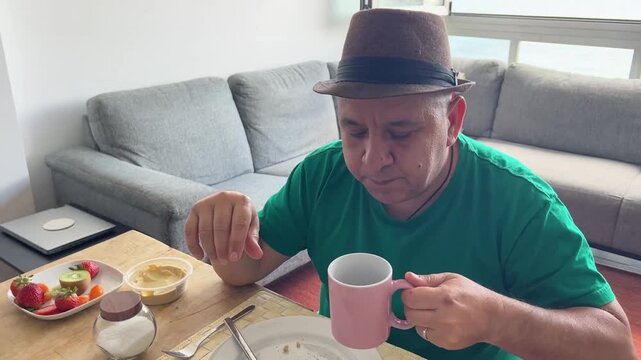 Hombre cogiendo taza de caf&eacute; y soplando