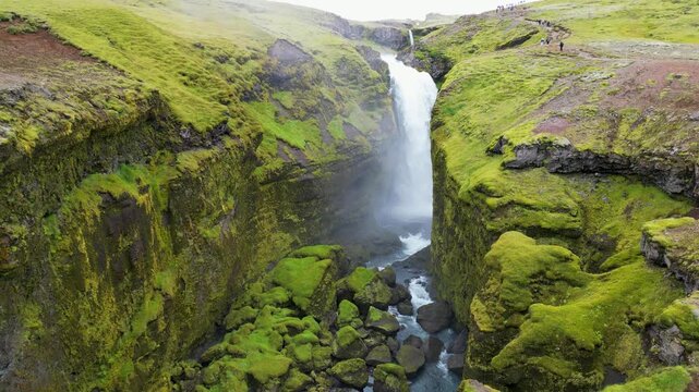 Skogafoss waterfall in Iceland with green mossy cliffs and mist