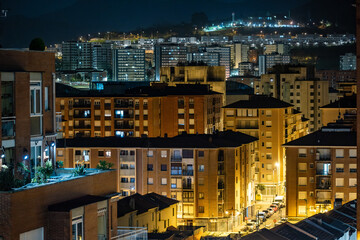 Fototapeta premium City buildings glowing at night in urban landscape
