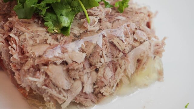 Prepared homemade beef aspic on plate, topping with parsley and dill. High quality 4k footage