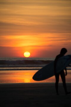 Silhouette of a male surfer walking on a beach at sunset carrying a surfboard, Playa Guiones, La Esperanza, Nosara, Canton Nicoya, Provincia Guanacaste, Costa Rica