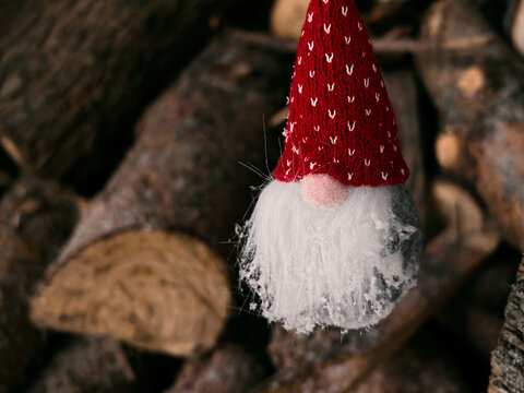 A Christmas gnome sits on a wood fire. The spirit of Christmas. Merry Christmas and a Happy New Year!