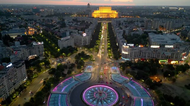 Aerial view of Palace of the Parliament at night, Bucharest, Romania. Landmark administrative building with city lights, 4K drone footage.