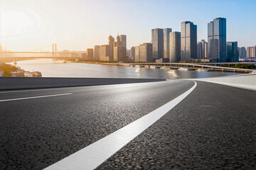 Fototapeta premium Asphalt Road Leading to Urban Skyscrapers and River