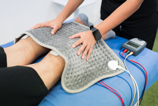 Patient receiving physical therapy with electric stimulation and heat