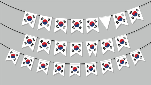 Decorative bunting made of South Korean flags on three strings, arranged over a neutral grey background for a celebration.