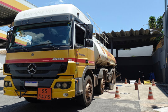Tanker Truck Unloading Flammable Fuel at Gas Station During Logistics Operation