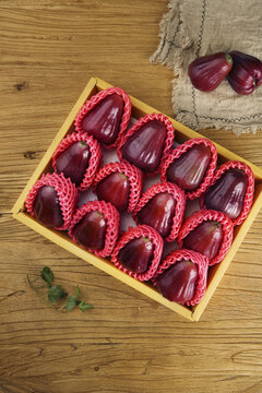 Fresh Hainan Black Diamond Wax Apples in Gift Box on Wooden Background
