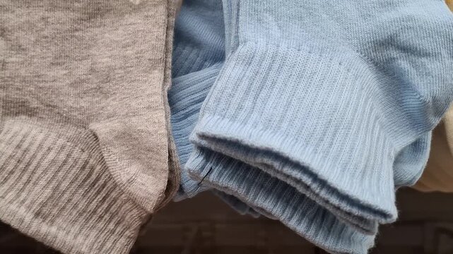 Close-up of high-quality cotton socks in white and melange grey colors. Soft knit texture and elastic ribbed cuffs of casual hosiery displayed in a clothing store or shop