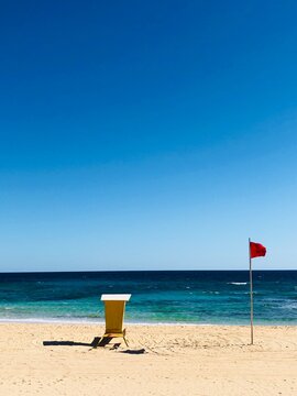 Lifeguard hut and red flag on a sandy beach, Corralejo, Las Palmas, Canary Islands, Spain