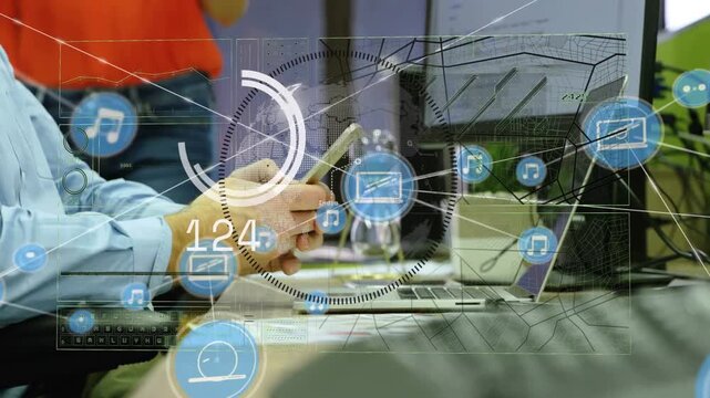 Seated man tapping phone in office while woman sorting papers behind him, HUD showing business data