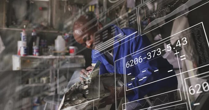 Male tech sanding damaged auto panel in shop, causing data panels tracking hands for repair