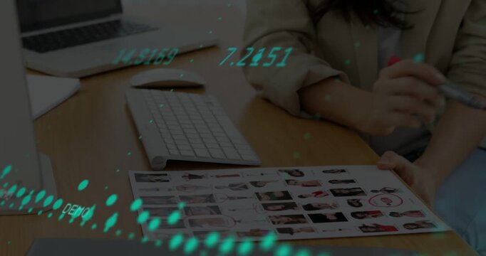 Vertical video: Woman using pen and marking sheet in design, causing teal dots and key digits