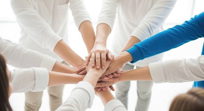 Diverse group of people stacking hands in a circle for teamwork and unity