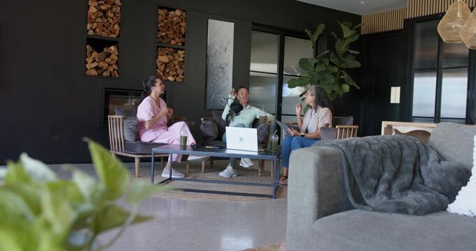 Microphone starting recording, three hosts speaking, gesturing and referencing laptop for podcast