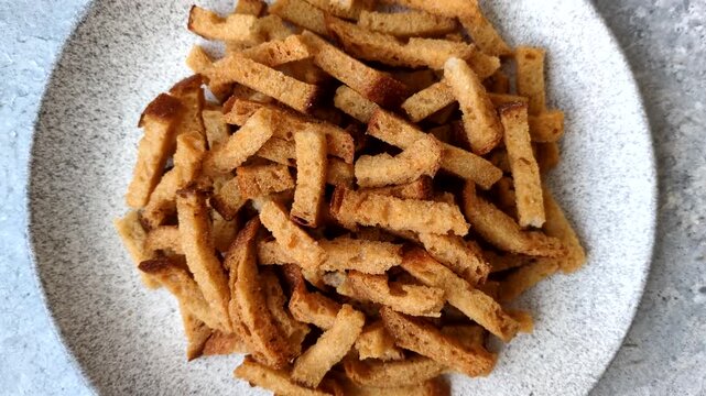 Croutons or crackers made from rye bread with garlic, salt, and spices, a salad ingredient. Croutons with salt and garlic as a food background for your design
