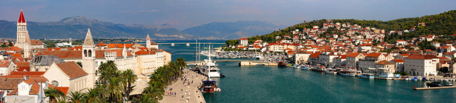 Trogir Croatia 15k huge panorama of UNESCO old town and marina with yachts. Scenic view from bridge of Venetian towers and ships in canal. Red roofs and white stone architecture of Dalmatia