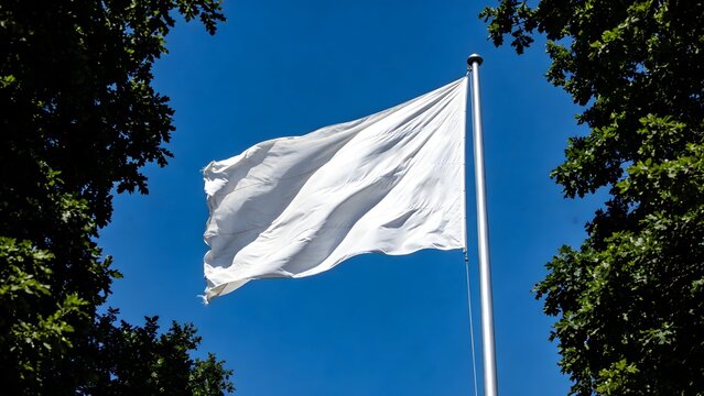 A stark white surrender flag waves proudly on a metal flagpole against a vibrant clear blue summer sky