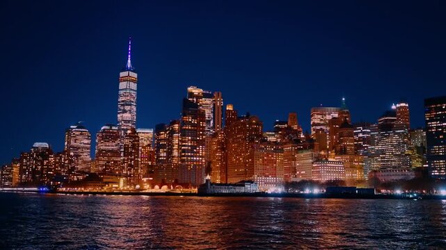 Spectacular skyline of New York with luminous architecture. View on the city from river at night.