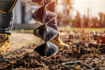Detail of hand-held soil hole drilling machine or portable manual cordless earth auger for prepare the soil for planting plants. © Peter