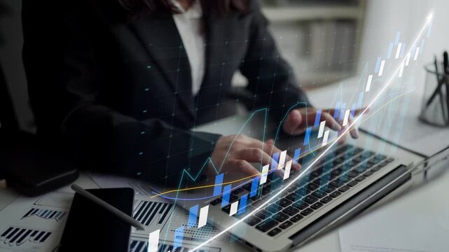 A professional dressed in business attire analyzes financial data on a laptop surrounded by modern charts and graphs, depicting growth and market trends in a contemporary office setting. Copula