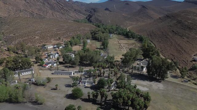 Camera moving sideways over the small historic town of Wupperthal. Wupperthal village is an isolated historical town in Cederberg known for its whitewashed thatch roof houses, 4K Aerial video.