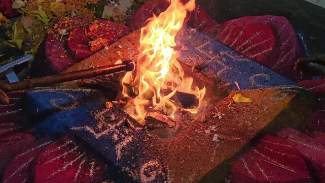 Hindu havan yajna ritual with sacred fire burning at the center of a decorated altar. The scene captures spiritual worship, offerings, and traditional religious ceremony. Ideal for themes of devotion