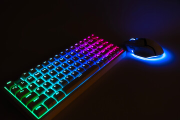 Wireless gaming keyboard and mouse with neon RGB backlighting. Modern gamer setup on a dark background. Esports and technology concept © Om.Nom.Nom