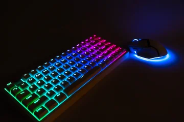 Fotobehang Gaming Wireless gaming keyboard and mouse with neon RGB backlighting. Modern gamer setup on a dark background. Esports and technology concept  © Om.Nom.Nom