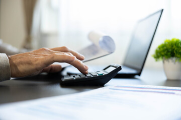 Obraz premium Hand pressing buttons on a calculator, processing financial data, managing budget in an office environment