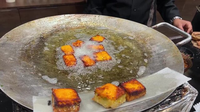 Freshly fried golden-brown Besan Vadas being prepared for spicy Aloo Tikki Chaat in India
