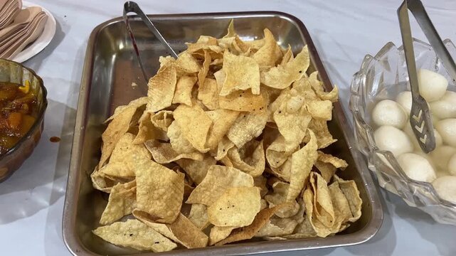 Crispy Indian Masala Papad: A crunchy deep-fried lentil cracker topped with spicy chopped onions, tomatoes, and fresh coriander