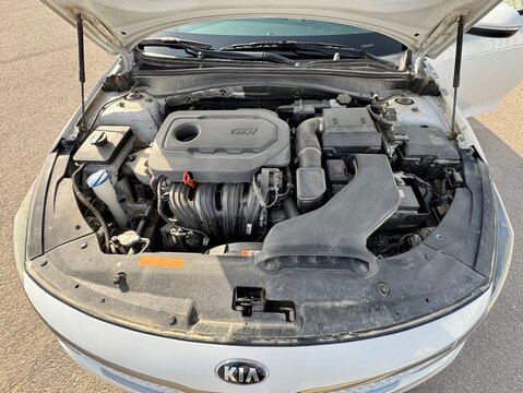 A high-angle, detailed shot of the engine compartment of a 2017 Kia Optima, featuring the 2.4L GDI (Gasoline Direct Injection) power unit.