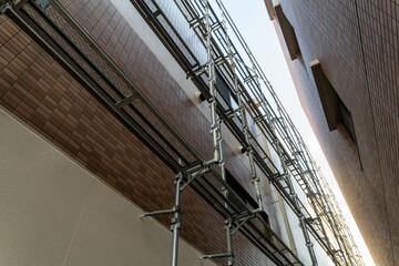 Obraz premium マンション外壁補修工事の足場と青空の建設現場